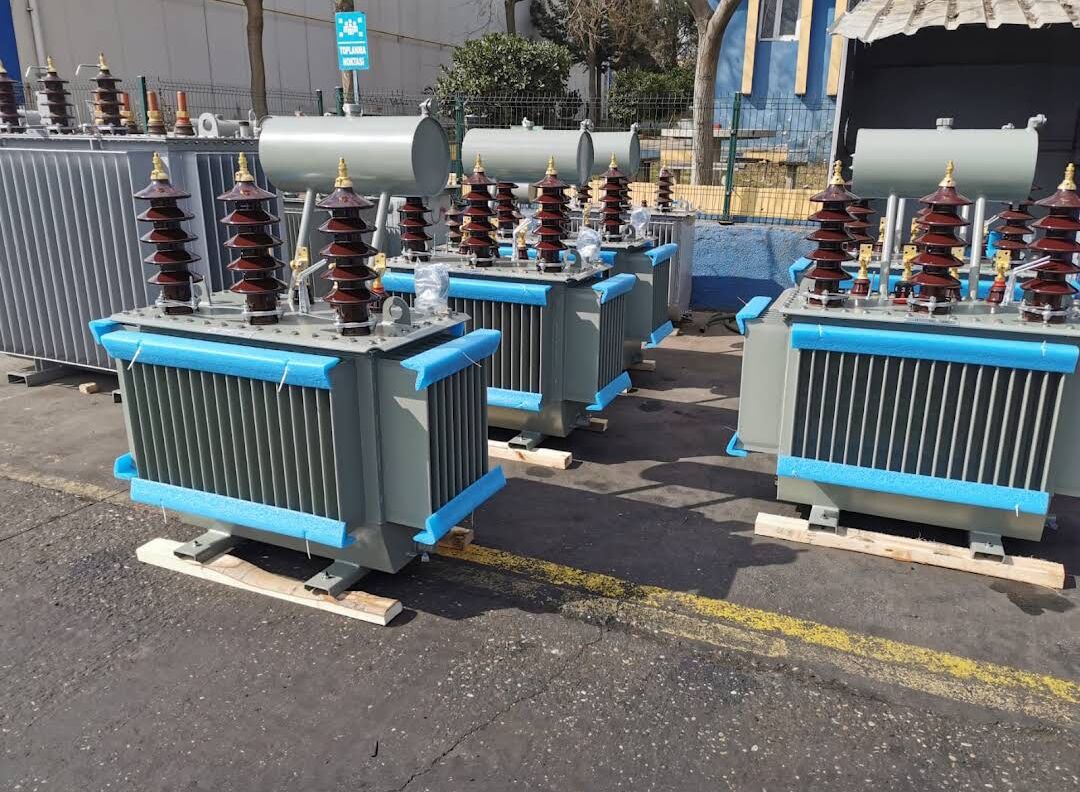 Grey oil-type transformers with brown porcelain bushings outdoors